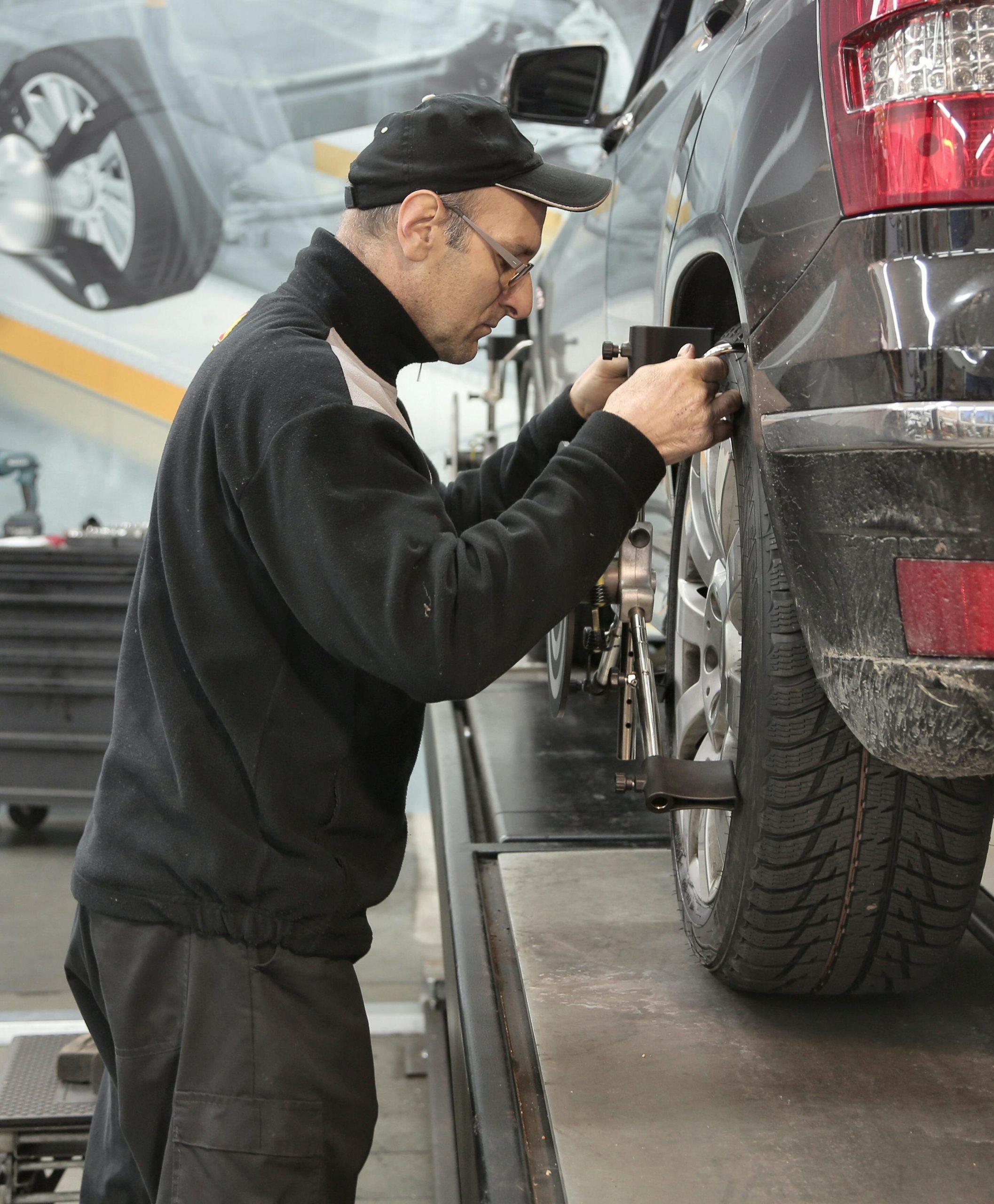 Technician checking wheel alignment after tire installation