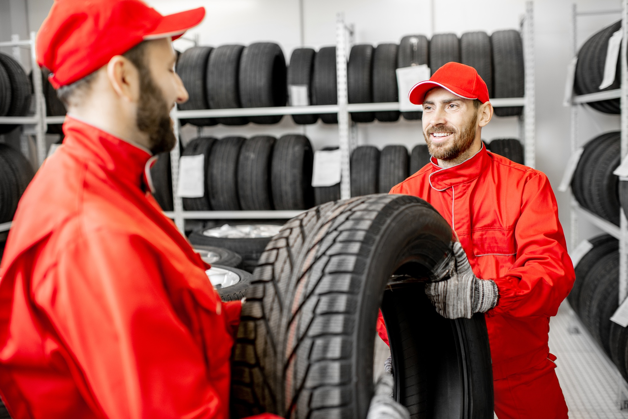 Tire-service technicians comparing replacement tires